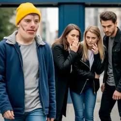 A person with visible differences being subject to unpleasant comments by strangers