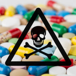 Multi-coloured tablets and pills with a black skull and crossbones warning triangle superimposed