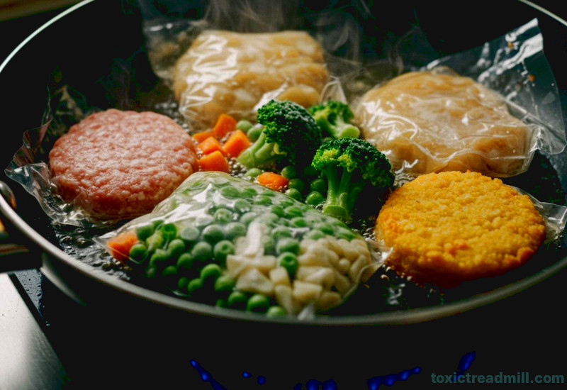 Several packets of food wrapped in plastic cooking in a frying pan